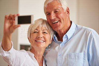 Buy stock photo Shot of a senior couple taking a selfie with their cellphone