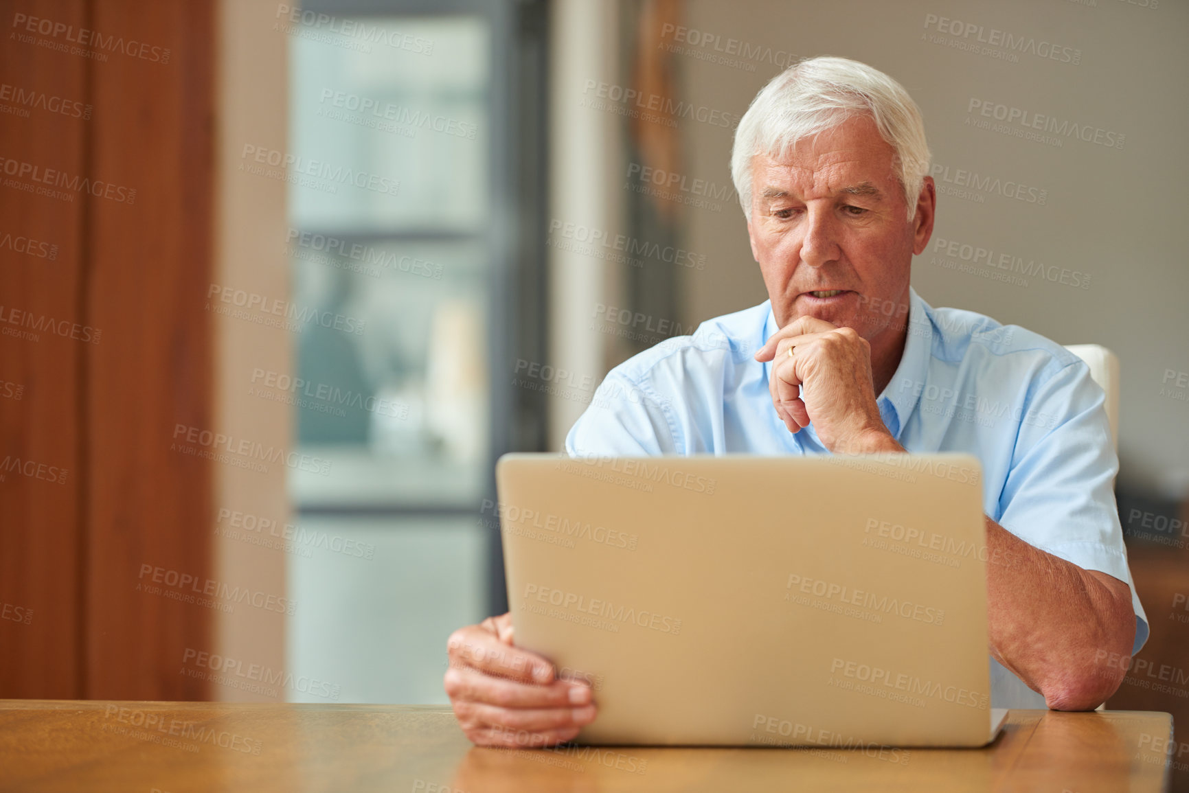 Buy stock photo Shot of a senior man using a laptop at home