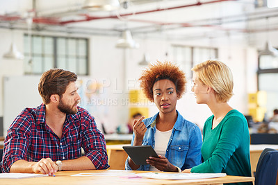Buy stock photo Shot of a group of colleagues  using a digital tablet together in an office