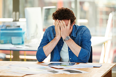Buy stock photo Shot a frustrated designer sitting at his desk