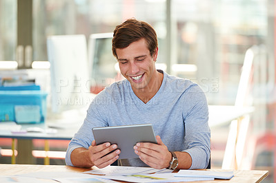 Buy stock photo Shot of a designer using a digital tablet while working in an office