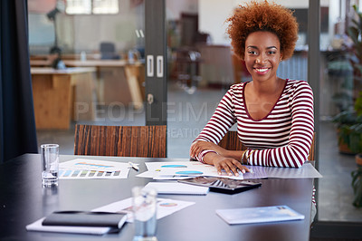 Buy stock photo Portrait of a young businesswoman sitting at a table in an office
