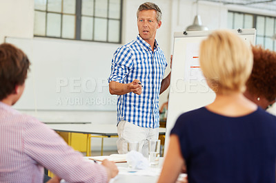Buy stock photo Shot of a mature businessman conducting a presentation in an office