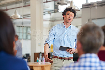 Buy stock photo Shot of designer giving a presentation to his colleagues using a digital tablet