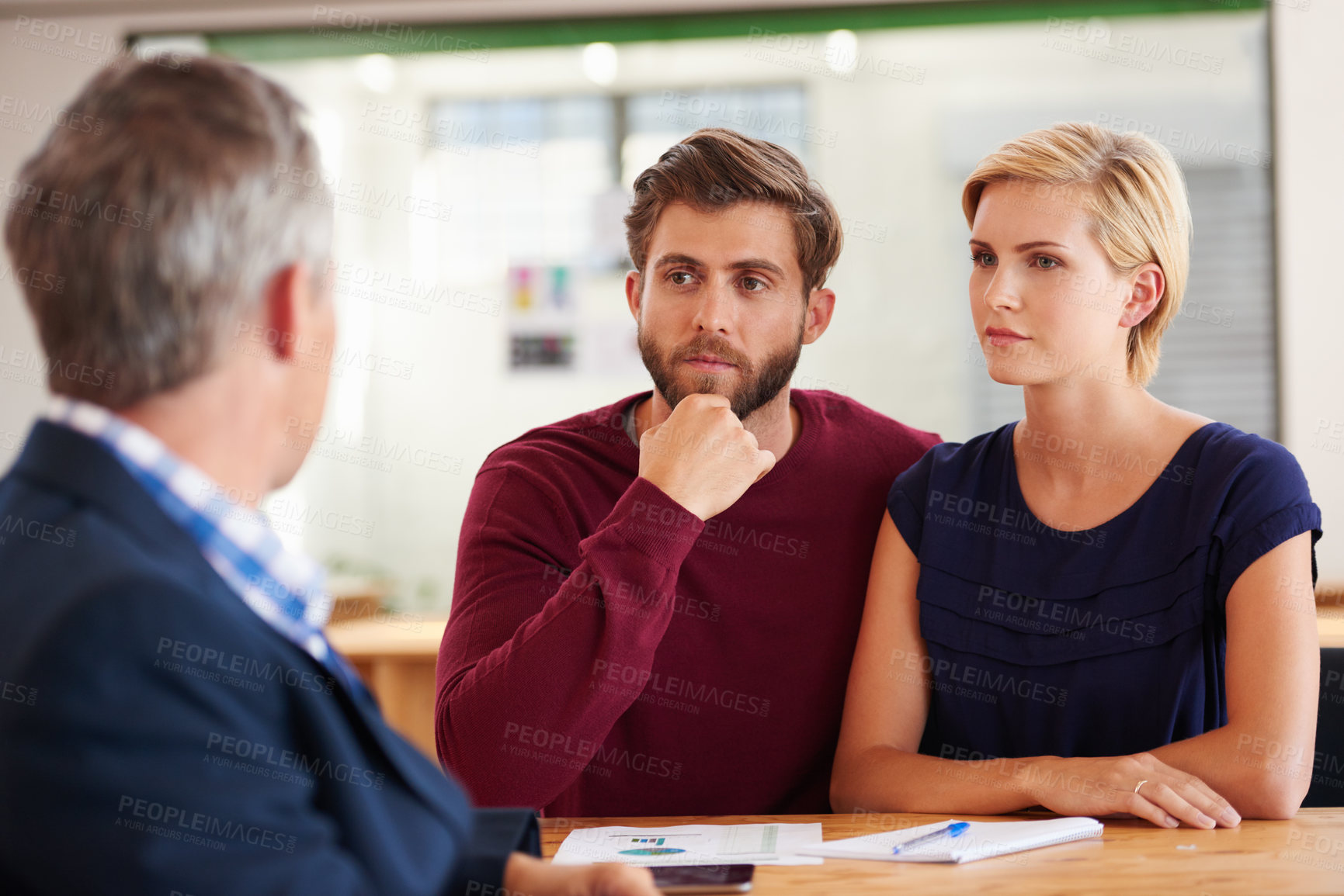 Buy stock photo Young couple discussing investment plans with a financial advisor