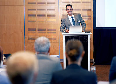 Buy stock photo Businessman, presentation and conference with laptop for team meeting, staff training or seminar at the office. Man, employee or speaker talking with smile on podium for company or business workshop