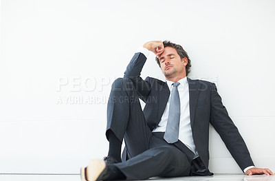 Buy stock photo Handsome business man taking a quick nap sitting against wall