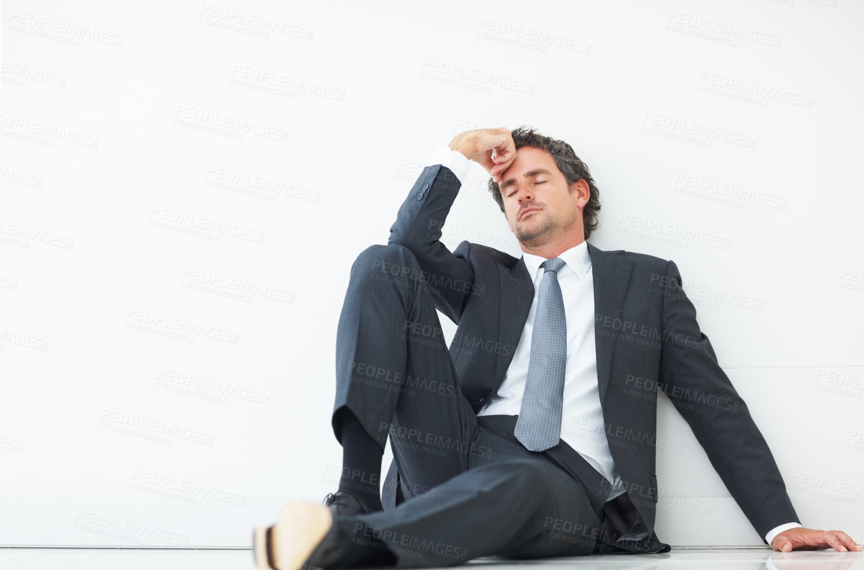 Buy stock photo Tired, businessman and on floor with anxiety, headache and stress isolated by white background for mockup. Professional, male lawyer and depression in studio for career and mental health in law firm