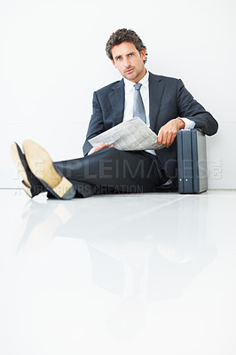 Buy stock photo Portrait of handsome business man sitting against wall with newspaper and suitcase