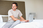 Man using laptop in bed