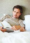 Relaxed man reading book at home
