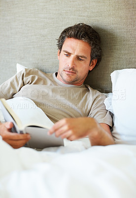 Buy stock photo Man, reading and relax in bed with book, storytelling or learning about self care, information or knowledge. Mature, person and research history in biography, novel or fiction in home or bedroom
