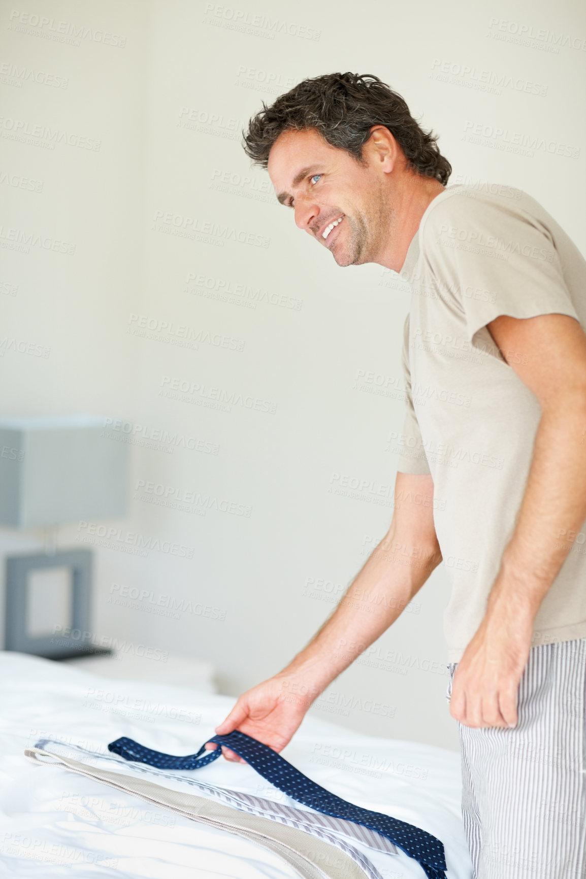 Buy stock photo Man, getting ready and choose tie to wear at work in morning and smile for choice in bedroom. Fashion, shirt and deciding on outfit for business meeting, proud and confident with face and happy