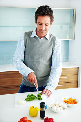 Buy stock photo Portrait of a handsome mature man cooking in the kitchen