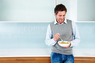 Buy stock photo Handsome mature man holding fruit salad while standing in kitchen
