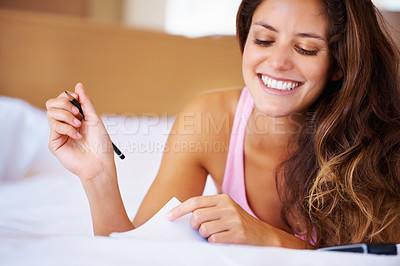 Buy stock photo Female student and smile while studying in bedroom with pencil, notes or paperwork for school. Young, woman and excited expression for learning, education or university coursework with book in home