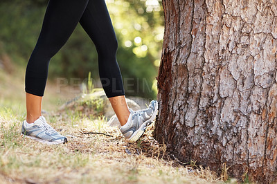 Buy stock photo Closeup, legs and tree with woman, stretching and fitness with exercise, forest or training for wellness, fresh air or outdoor. Person, runner or athlete with sneakers, workout or warm up with health