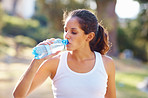 Woman drinking a bottle of water after jogging