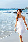 Beautiful young woman walking on beach