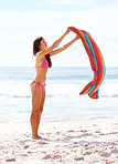 Attractive young girl with a towel on the beach