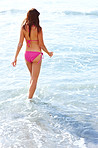 Young female walking in water at the beach