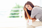 Young thoughtful female with coffee at the bedroom