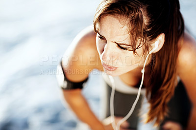 Buy stock photo Tired, pain and sports woman outdoor for thinking, breathe or body health at beach. Fatigue, fitness and person resting on break for listening to radio music, audio or relax on earphones for wellness