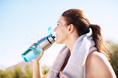 Buy stock photo Closeup shot of an attractive woman drinking from her water bottle after a workout