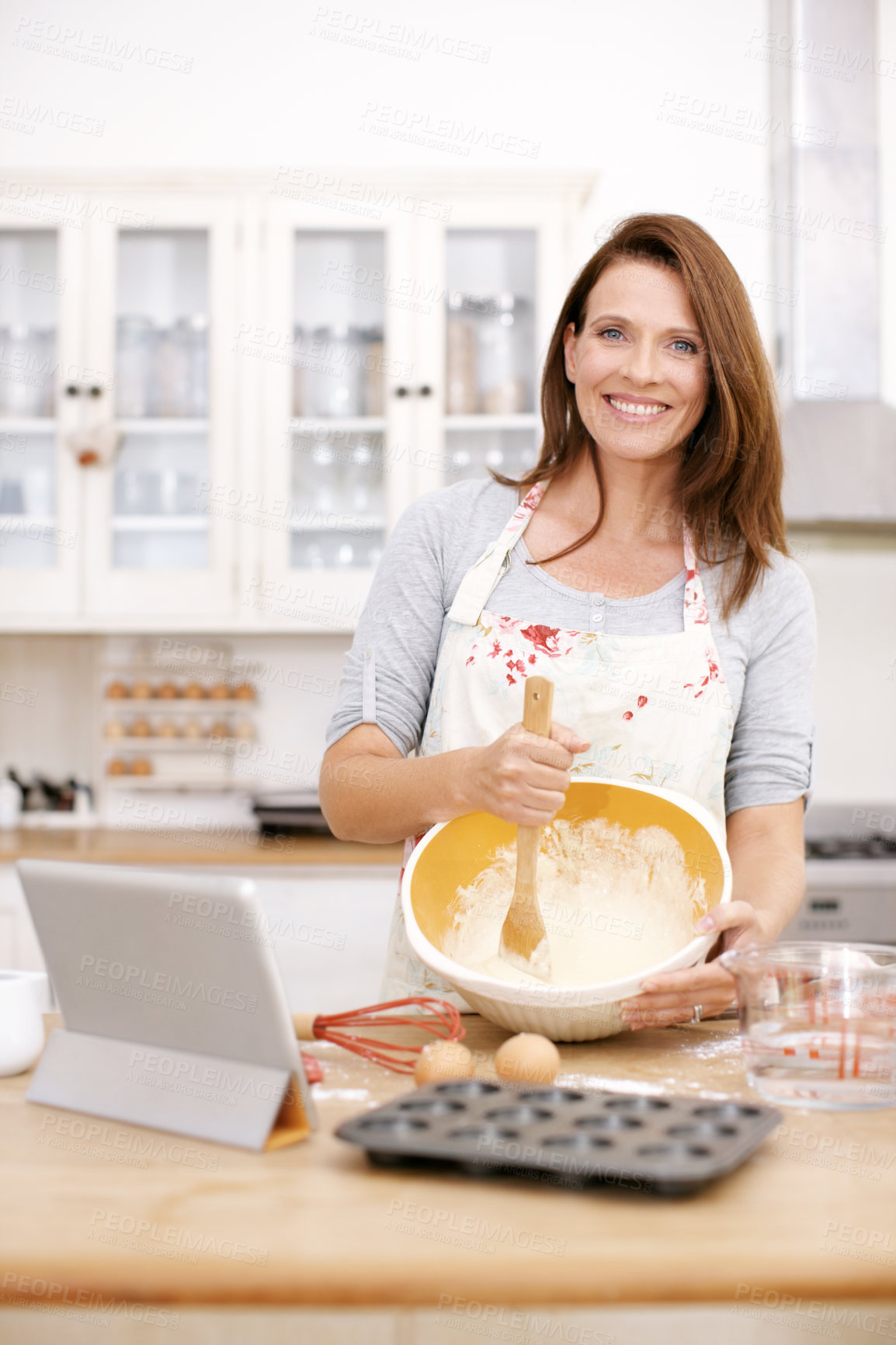 Buy stock photo Woman baker, portrait and bowl in kitchen counter for sweet dessert, cookies or cupcakes in home. Baking, flour and happy female person with tablet for mixing ingredients, recipe or cake on Easter