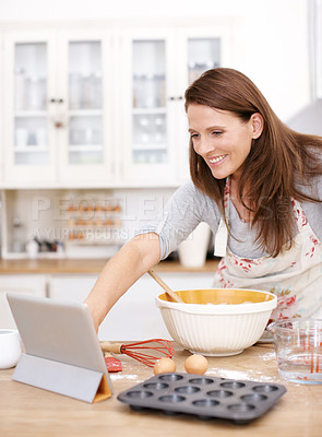 Buy stock photo A mature woman looking for baking recipes online