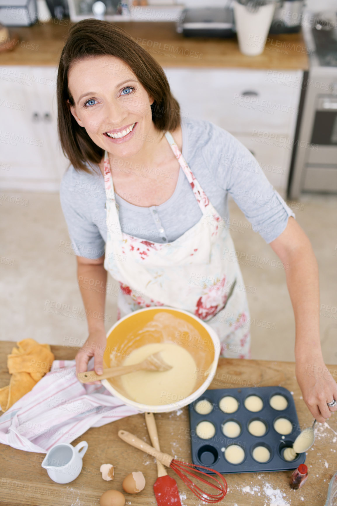 Buy stock photo Above, cupcake and portrait of woman baking in home and confident chef in process on kitchen counter. Girl, cooking and meal prep of dessert, sweets and bowl with mixture for production of food 