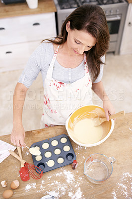 Buy stock photo Overhead view of a mature woman placing cake mix into a baking tray