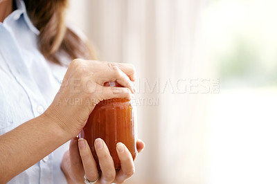 Buy stock photo Cropped image of a woman struggling to open a jar in the kitchen