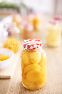 Buy stock photo Closeup image of a closed bottle of preserved peaches with other bottles in the background