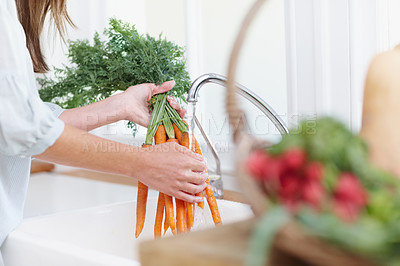 Buy stock photo Woman, water and washing carrots in kitchen for wellness, food and nutrition in apartment. Vegan, basket and health for cooking, diet and organic vegetables in home with vitamins and female person