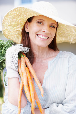 Buy stock photo Portrait of a smiling woman holding up a bunch of carrots