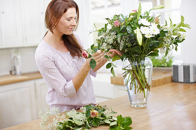 Buy stock photo A beautiful woman woman arranging a fresh bouquet of flowers