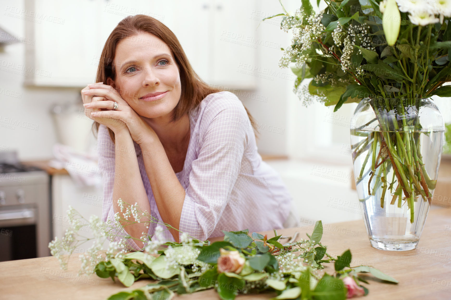 Buy stock photo A beautiful woman in the process of arranging a bouquet of flowers
