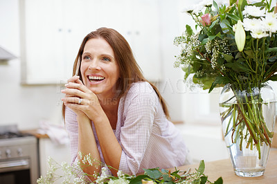Buy stock photo A beautiful woman in the process of arranging a bouquet of flowers