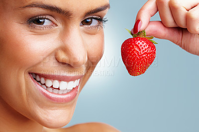 Buy stock photo Detail shot of a cheerful young woman holding a fresh strawberry