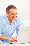 Cheerful elderly man  surfing on a laptop against white