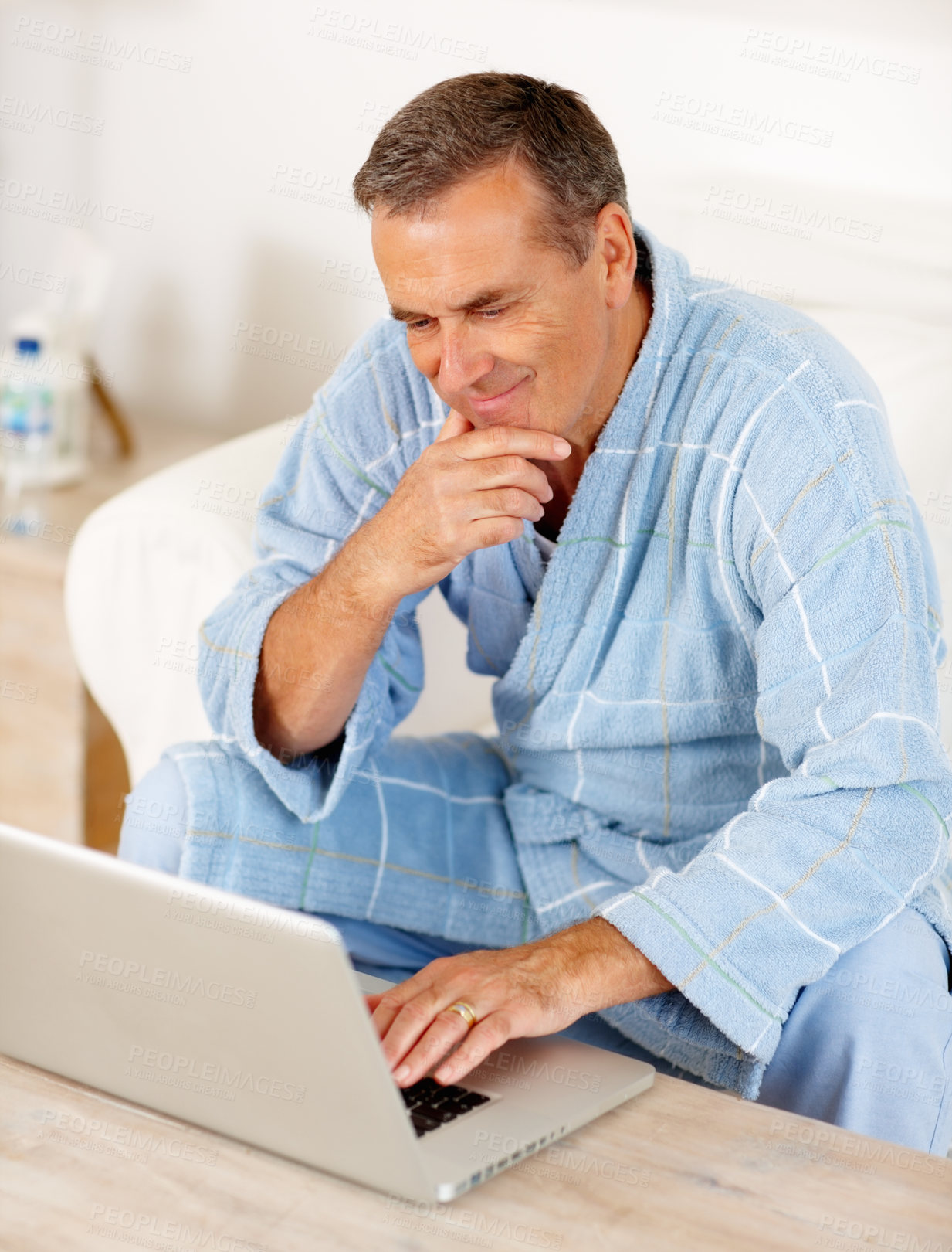 Buy stock photo Sofa, morning and mature man on laptop, checking email, social media or streaming subscription. Internet search, couch and happy senior person on computer, website or networking in bathrobe in home.