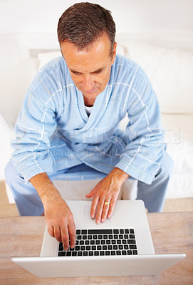 Buy stock photo Bathrobe, typing and mature man on laptop, checking email, social media or streaming subscription on sofa. Internet search, couch and senior person on home computer, website or networking from above.