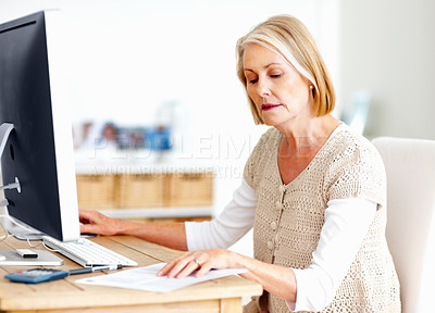 Buy stock photo Mature woman at desk with computer, documents and administration for business accounting. Report, review and senior businesswoman reading invoice paperwork for finance, budget and office management.