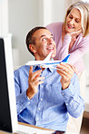 Couple in front of computer with a man holding toy airplane