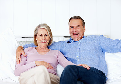 Buy stock photo Senior, couple and portrait or laugh on sofa with bonding, relationship and marriage in retirement home. Elderly, man and woman with smile on couch in living room with trust, care and love in house 