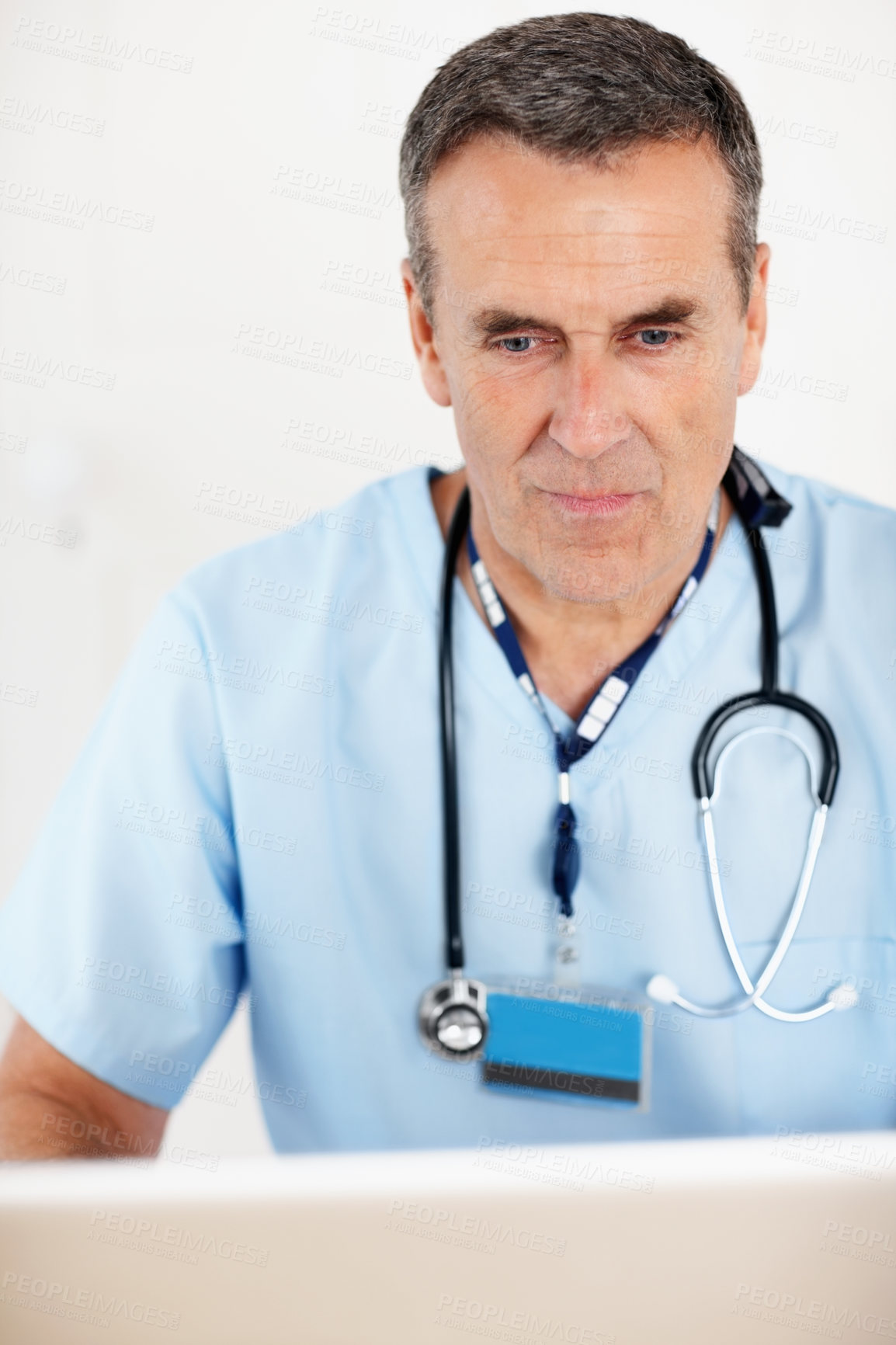 Buy stock photo Closeup portrait of a senior doctor with stethoscope working on laptop against white