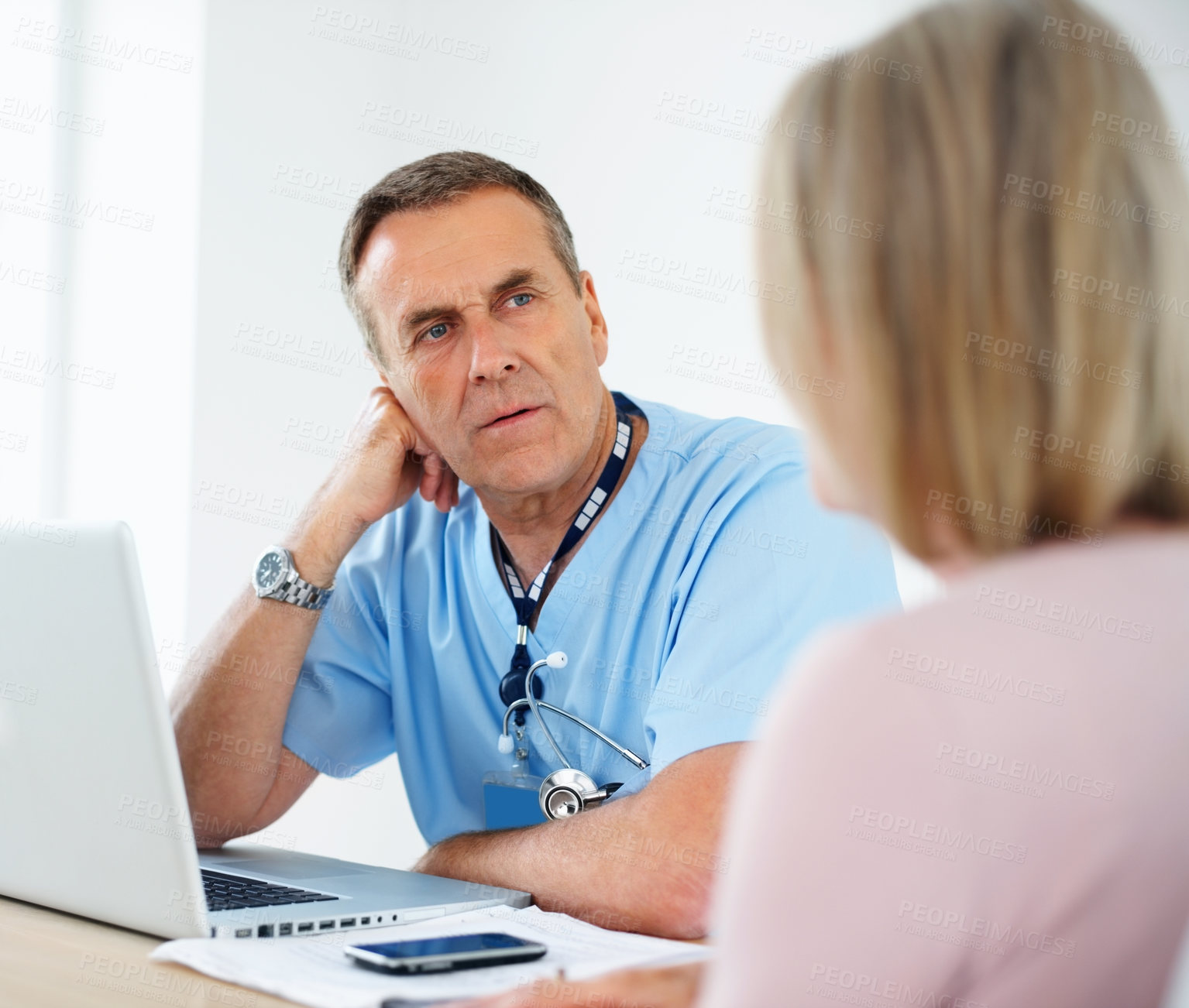 Buy stock photo Portrait of a serious medical doctor listening to female patient at clinic