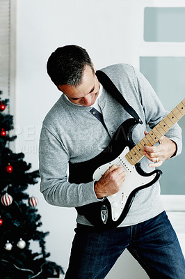 Buy stock photo Electric guitar, mature man and music for Christmas with gift, excited and fun in living room. Artist, male musician and instrument in lounge for present, creativity and play with happiness at home