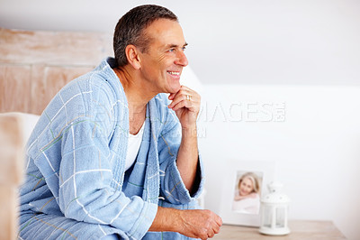 Buy stock photo Mature, man and happy for thinking on bed in home with memory, daydreaming and relax in bathrobe. Person, smile and thoughtful in bedroom with wondering, reflection and perspective with mockup space